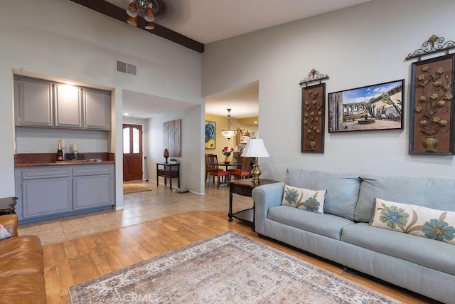 1130 Carob Ct, Hemet, CA 92545 - living room with light wood-type flooring, a bar, and lofted ceiling