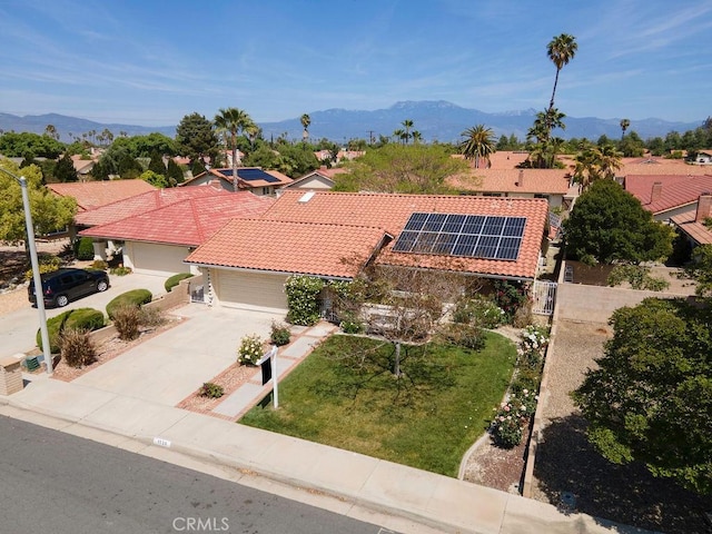 1130 Carob Ct, Hemet, CA 92545 - view of front of house featuring a tile roof, an attached garage, roof mounted solar panels, driveway, and a mountain view