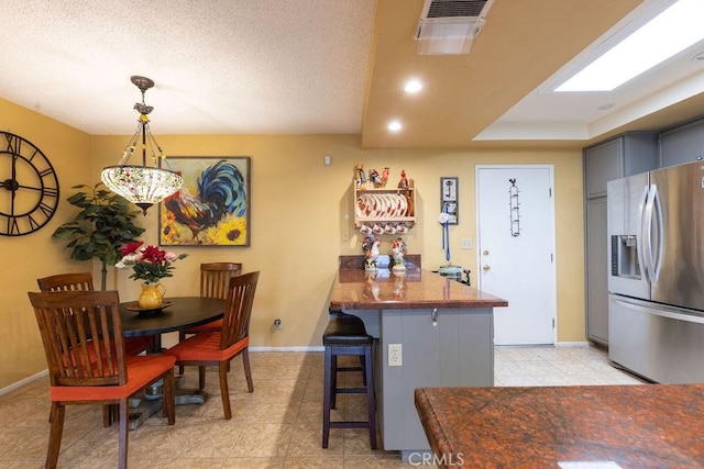 1130 Carob Ct, Hemet, CA 92545 - kitchen featuring stainless steel fridge with ice dispenser, a breakfast bar area, a peninsula, light tile patterned flooring, and gray cabinetry