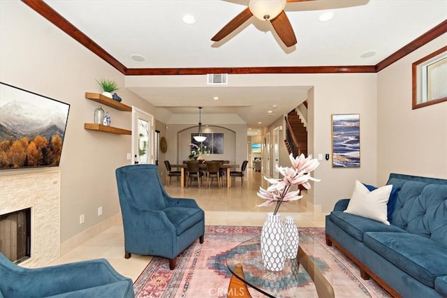 living room with tile patterned floors, a fireplace, visible vents, and a ceiling fan