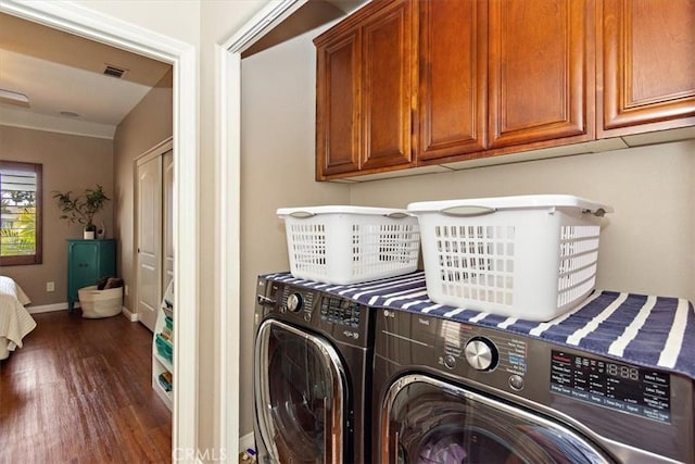laundry room with cabinet space, separate washer and dryer, dark wood-type flooring, visible vents, and baseboards