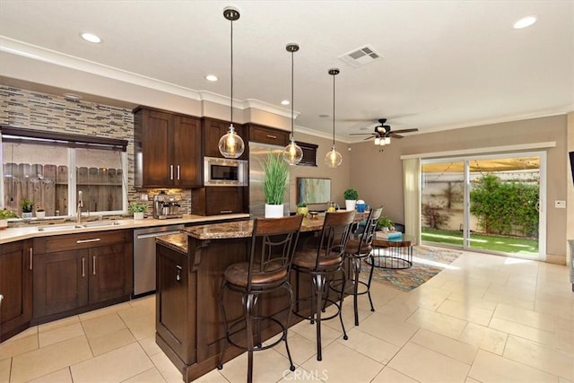 kitchen featuring stainless steel appliances, dark brown cabinets, ceiling fan, a sink, and visible vents
