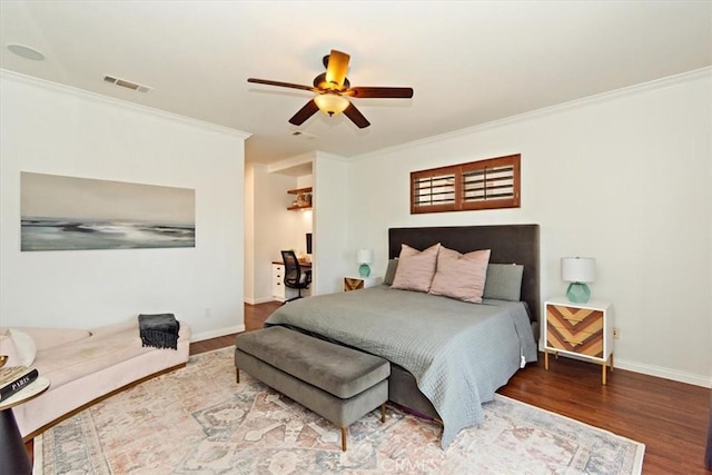 bedroom with crown molding, visible vents, wood finished floors, and baseboards