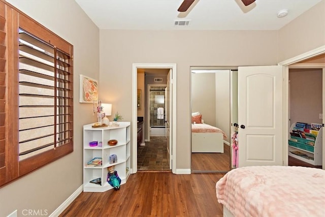 bedroom with baseboards, visible vents, wood finished floors, and a closet