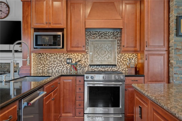 2645 S Patton Ave, San Pedro, CA 90731 - kitchen featuring brown cabinets, a sink, dark stone countertops, stainless steel appliances, and backsplash