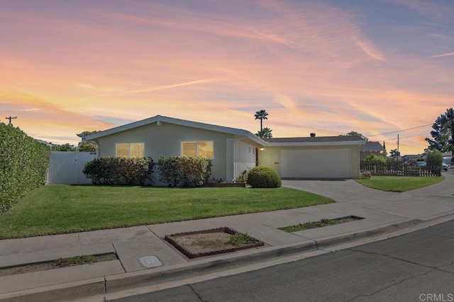 ranch-style home with stucco siding, driveway, an attached garage, a front lawn, and fence