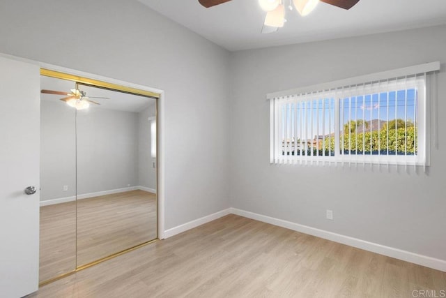 unfurnished bedroom with a closet, baseboards, a ceiling fan, and wood finished floors