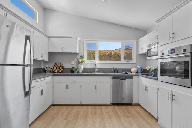 kitchen featuring appliances with stainless steel finishes, dark countertops, and a wealth of natural light