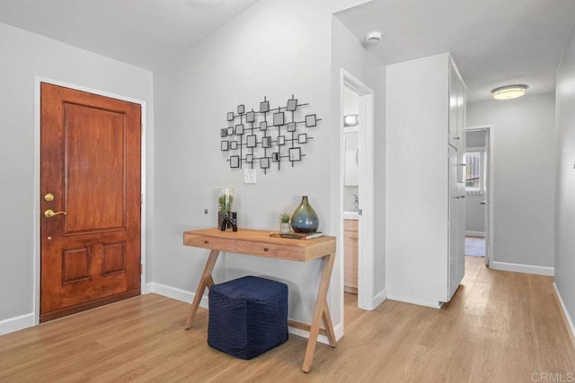 foyer featuring baseboards and light wood-style floors