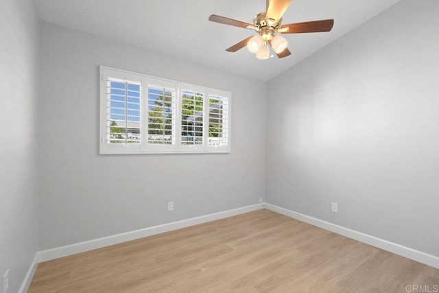 spare room featuring baseboards, light wood-type flooring, and a ceiling fan