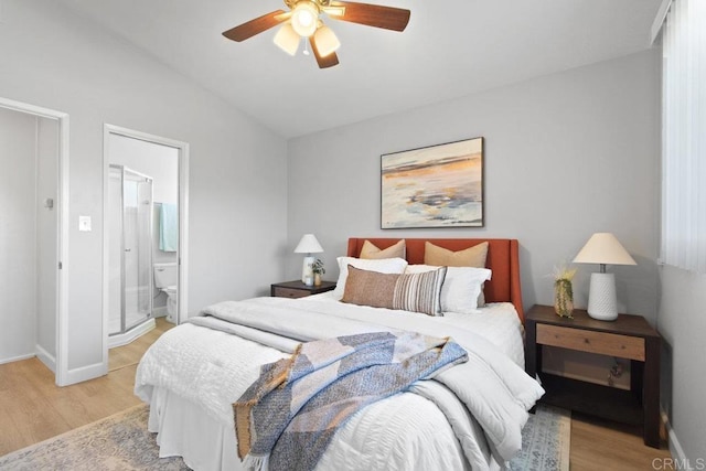 bedroom featuring lofted ceiling, baseboards, connected bathroom, ceiling fan, and light wood finished floors