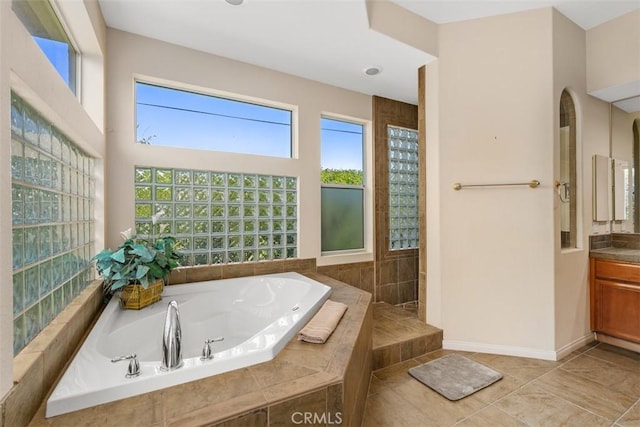 full bathroom featuring a bath, baseboards, vanity, and a walk in shower