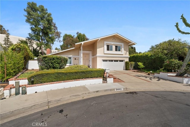 traditional-style house with a garage, stucco siding, and driveway