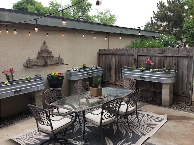 view of patio with fence and outdoor dining space