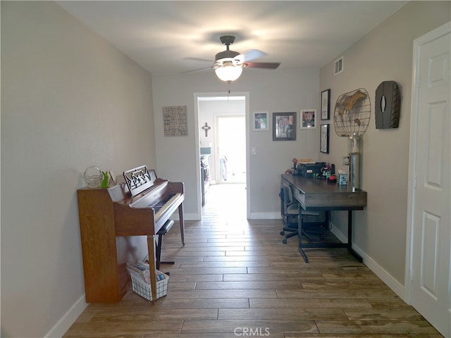 hall with baseboards, visible vents, and wood finished floors