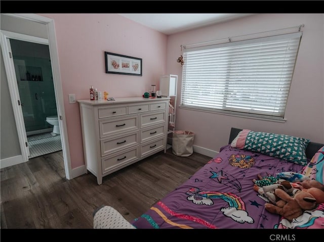 bedroom featuring baseboards, ensuite bathroom, and dark wood-type flooring