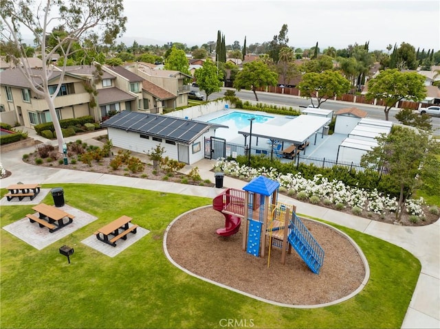 communal playground featuring a residential view, a yard, and fence