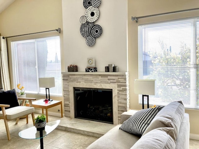 living area with a healthy amount of sunlight, baseboards, tile patterned flooring, and a fireplace