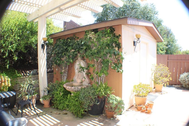 view of shed with fence and a pergola