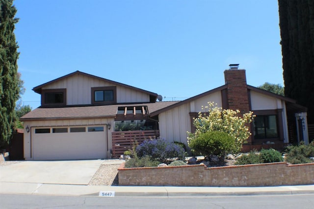 view of front facade with fence, a garage, board and batten siding, a chimney, and concrete driveway