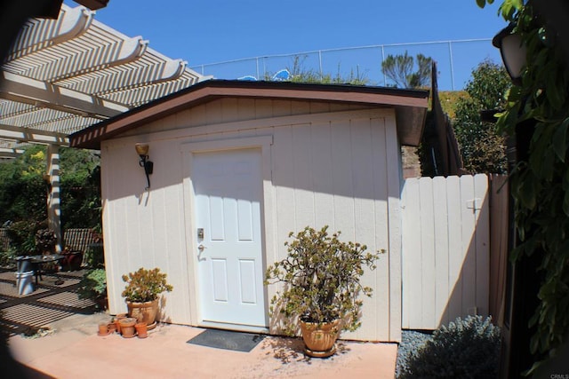 view of shed with fence and a pergola