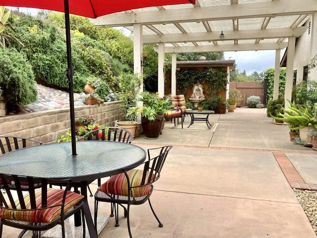 view of patio featuring fence, a pergola, and outdoor dining area