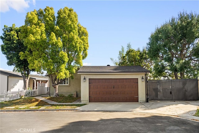 ranch-style home with concrete driveway, a garage, stucco siding, and fence