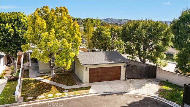 view of front of house featuring a mountain view, a shingled roof, an attached garage, concrete driveway, and stucco siding
