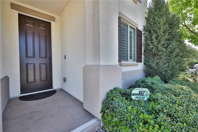 property entrance with stucco siding