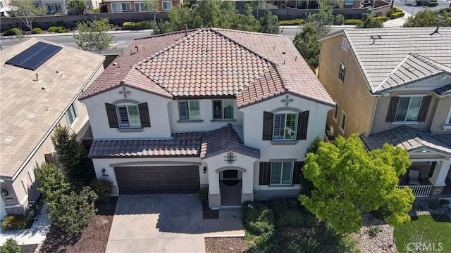 view of front of home with concrete driveway, stucco siding, and a tile roof