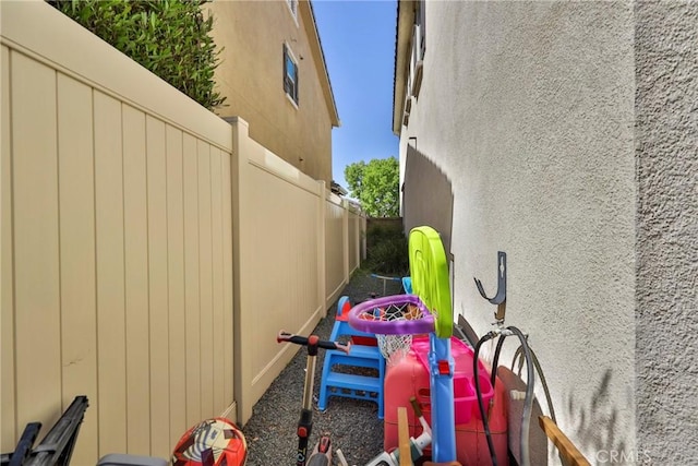 view of side of property with stucco siding and fence