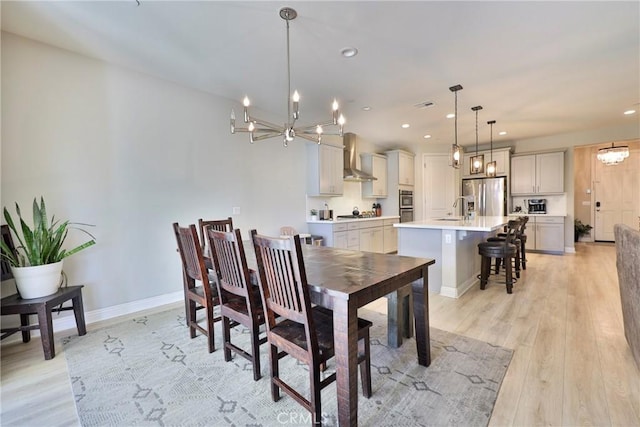 dining room with baseboards, light wood finished floors, a notable chandelier, and recessed lighting