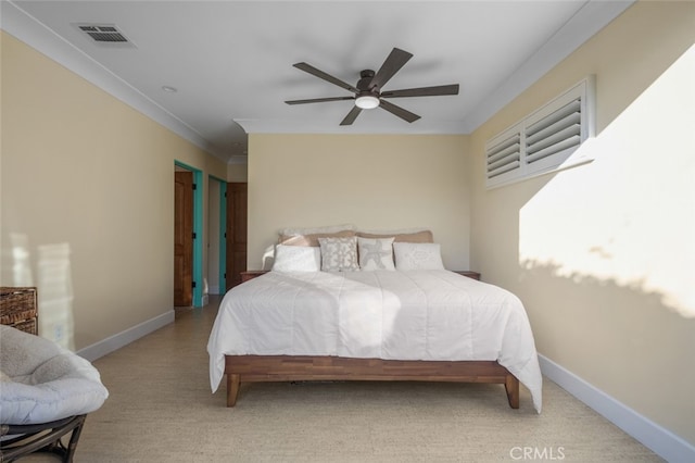 bedroom with visible vents, crown molding, baseboards, light colored carpet, and a ceiling fan