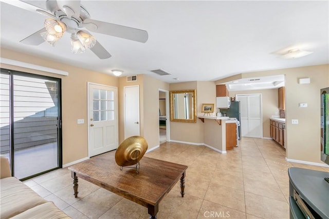 living room featuring visible vents, baseboards, a ceiling fan, and light tile patterned flooring