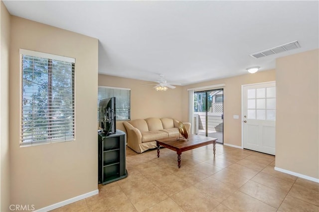 living area with visible vents, a ceiling fan, baseboards, and light tile patterned floors