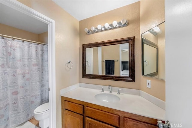 bathroom with a shower with shower curtain, toilet, and vanity