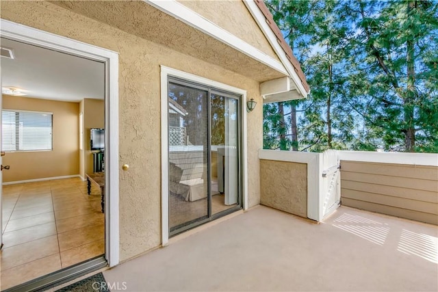 doorway to property featuring a patio, visible vents, and stucco siding