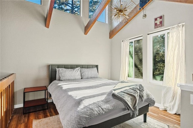 bedroom with baseboards, high vaulted ceiling, and wood finished floors