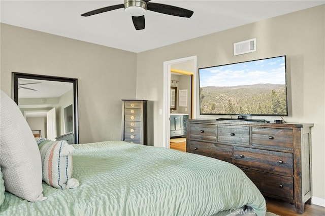 bedroom featuring visible vents, a ceiling fan, connected bathroom, and wood finished floors