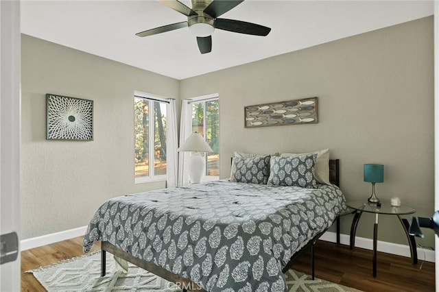 bedroom featuring baseboards, a ceiling fan, and wood finished floors