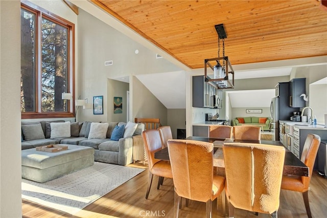 dining space featuring visible vents, lofted ceiling, wood finished floors, and wood ceiling