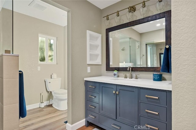 full bathroom with baseboards, toilet, a textured wall, vanity, and wood finished floors