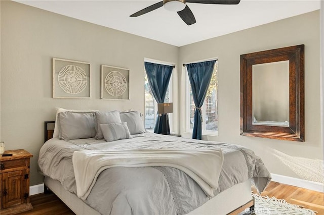 bedroom with dark wood-style flooring, baseboards, and a ceiling fan
