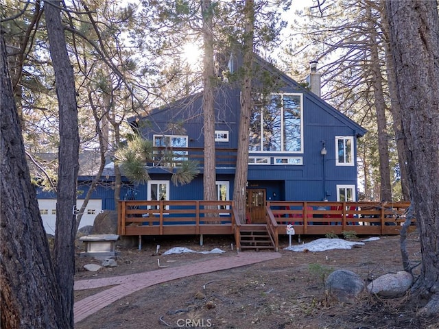 view of front of home featuring french doors, a chimney, and a wooden deck