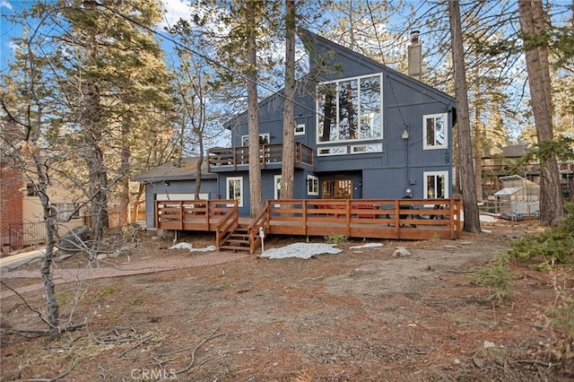 rear view of property with a deck and a chimney