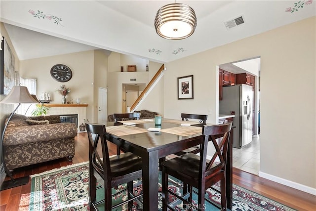 22690 Mountain View Rd, Moreno Valley, CA 92557 - dining room featuring stairs, baseboards, wood finished floors, a tile fireplace, and visible vents