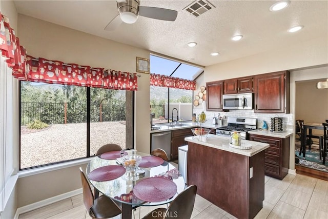 22690 Mountain View Rd, Moreno Valley, CA 92557 - kitchen with backsplash, visible vents, a sink, light countertops, and stainless steel appliances