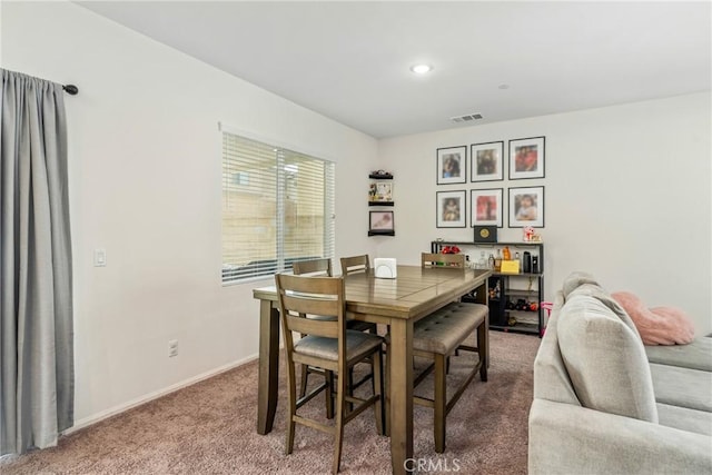 carpeted dining space with visible vents and baseboards