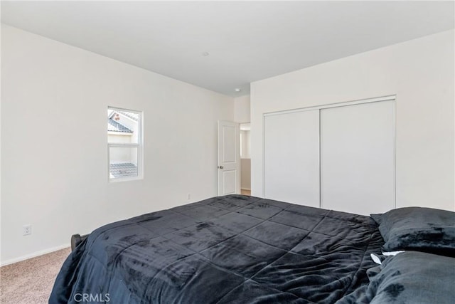 bedroom featuring baseboards, a closet, and dark carpet