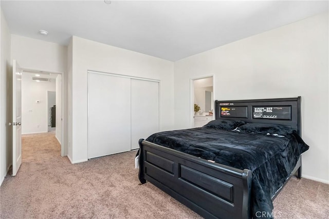 carpeted bedroom featuring a closet and baseboards
